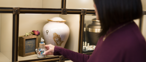 woman placing keepsakes in a cremation niche