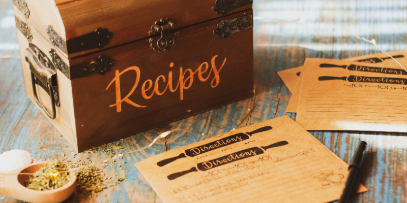 a wooden recipe box on a counter with recipe cards