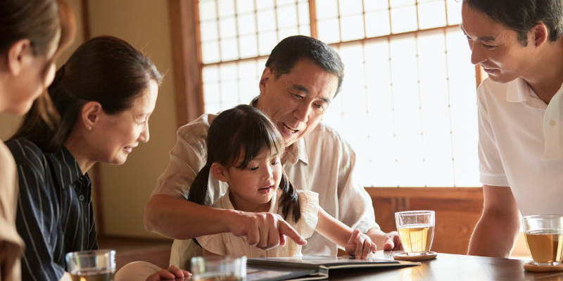 a family around the table sharing a story and enjoying drinks together