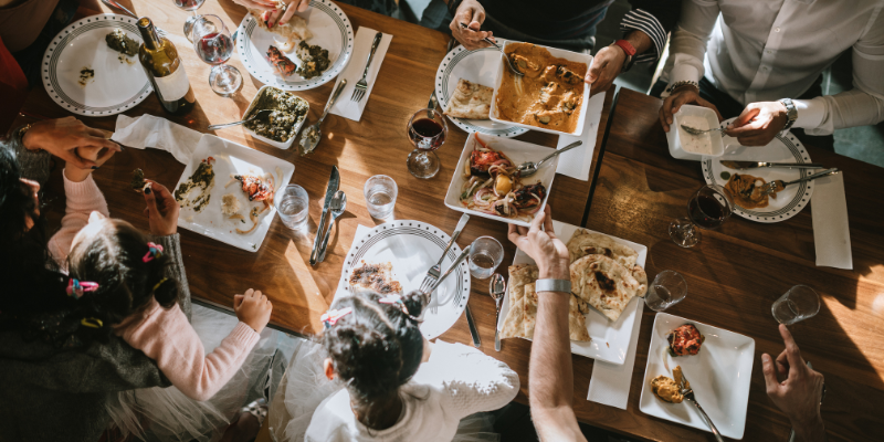 a group of people around a table enjoy a meal